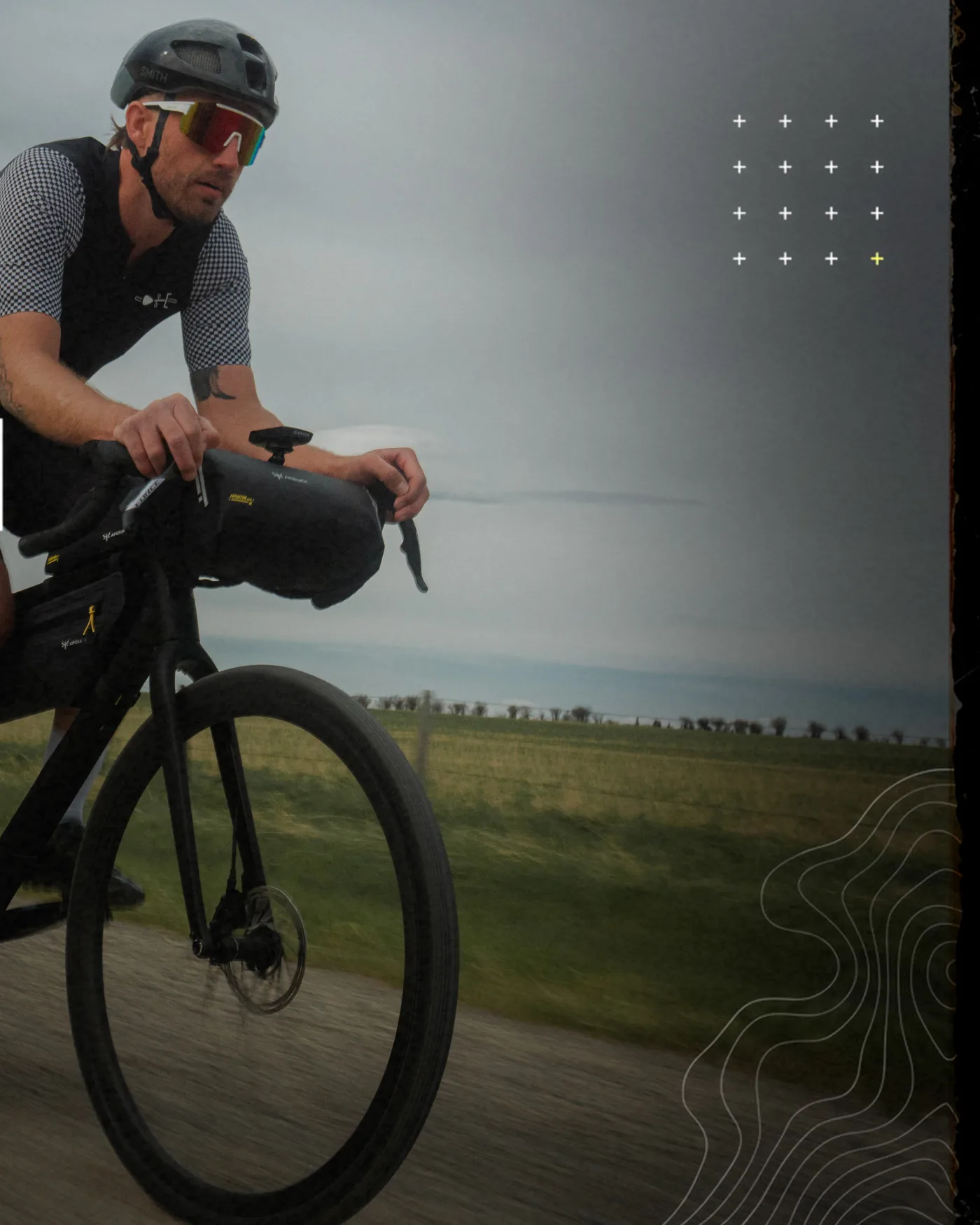 Carousel slide 3 — rider on a loaded gravel bike under a moody prairie sky