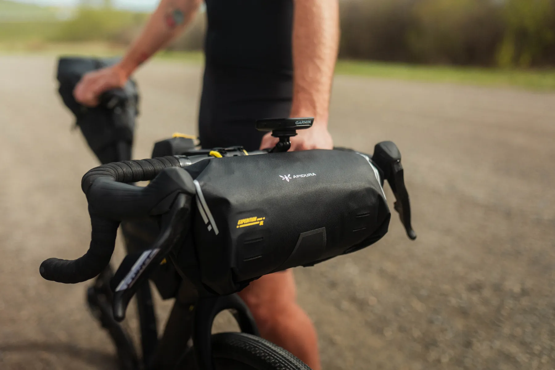 Apidura Expedition handlebar pack mounted on the bars of a gravel bike