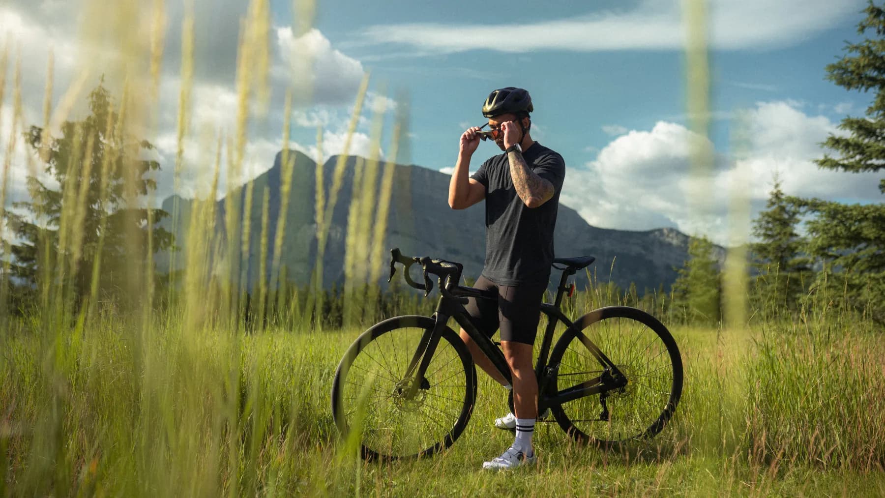 Cyclist setting his Spek glasses in place in a mountain meadow