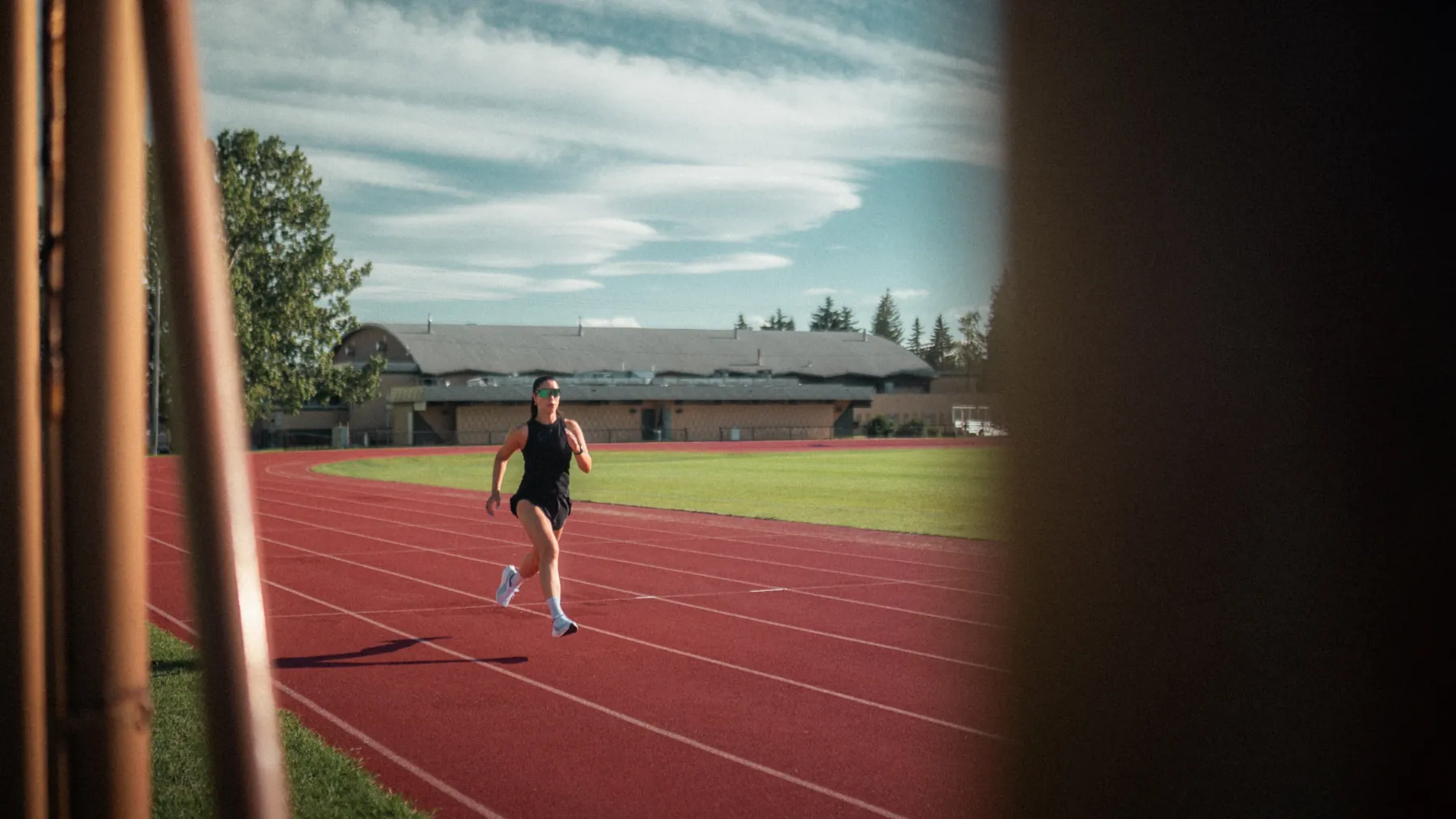 Sprinter in Spek glasses mid-stride on a red running track